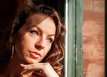 Professional portrait of a woman with green eyes in Chicago on a window