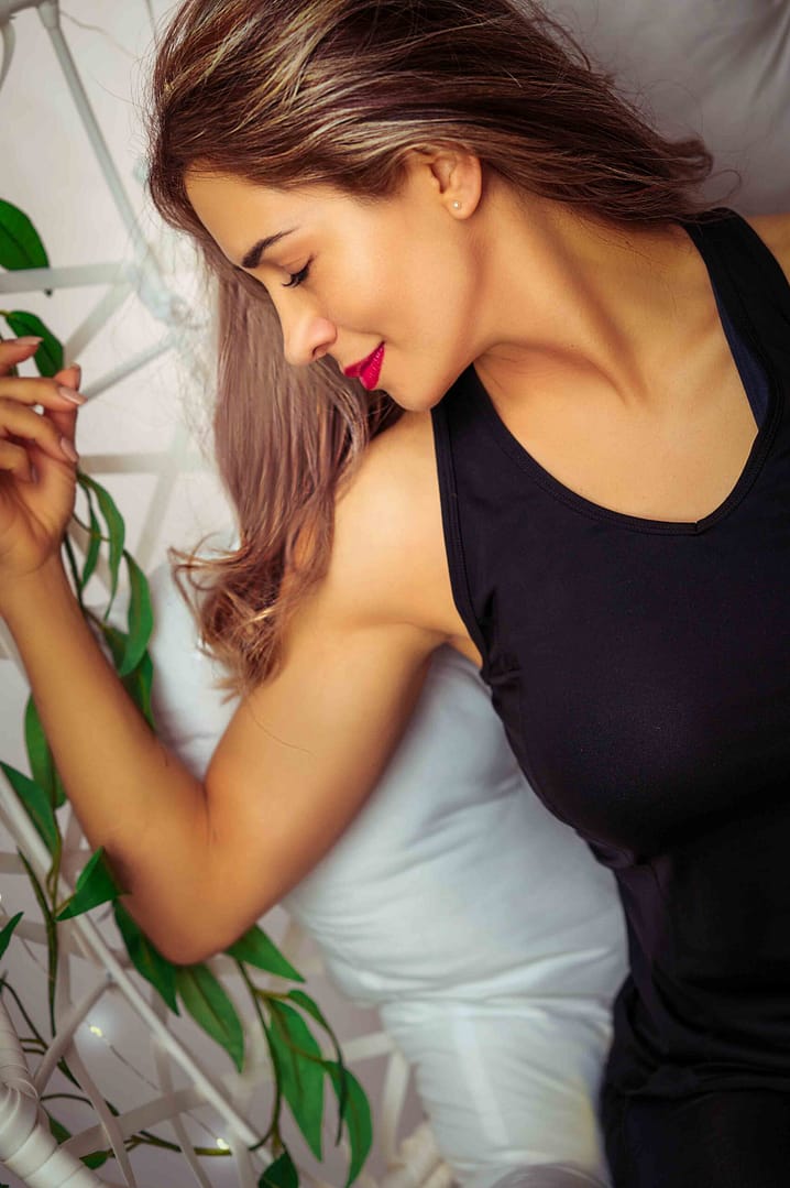 Empowering portrait of a smiling woman with red lipstick relaxing on a white bed. captured by Nickolaus21 in Chicago