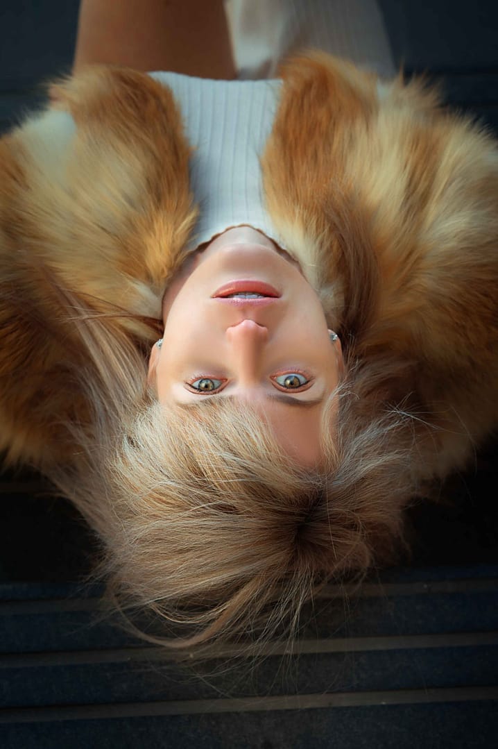 Woman lying down wearing fur coat, photographed from above — Empowering Portraits Chicago by Nickolaus21
