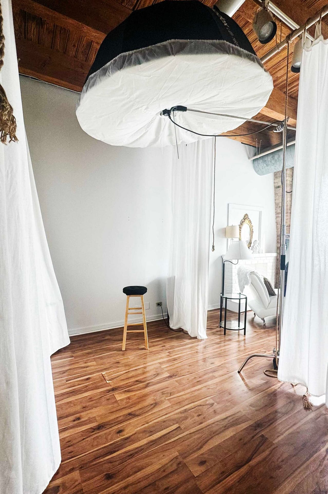 Wide view of industrial-chic Chicago photography loft with wood beam ceiling
