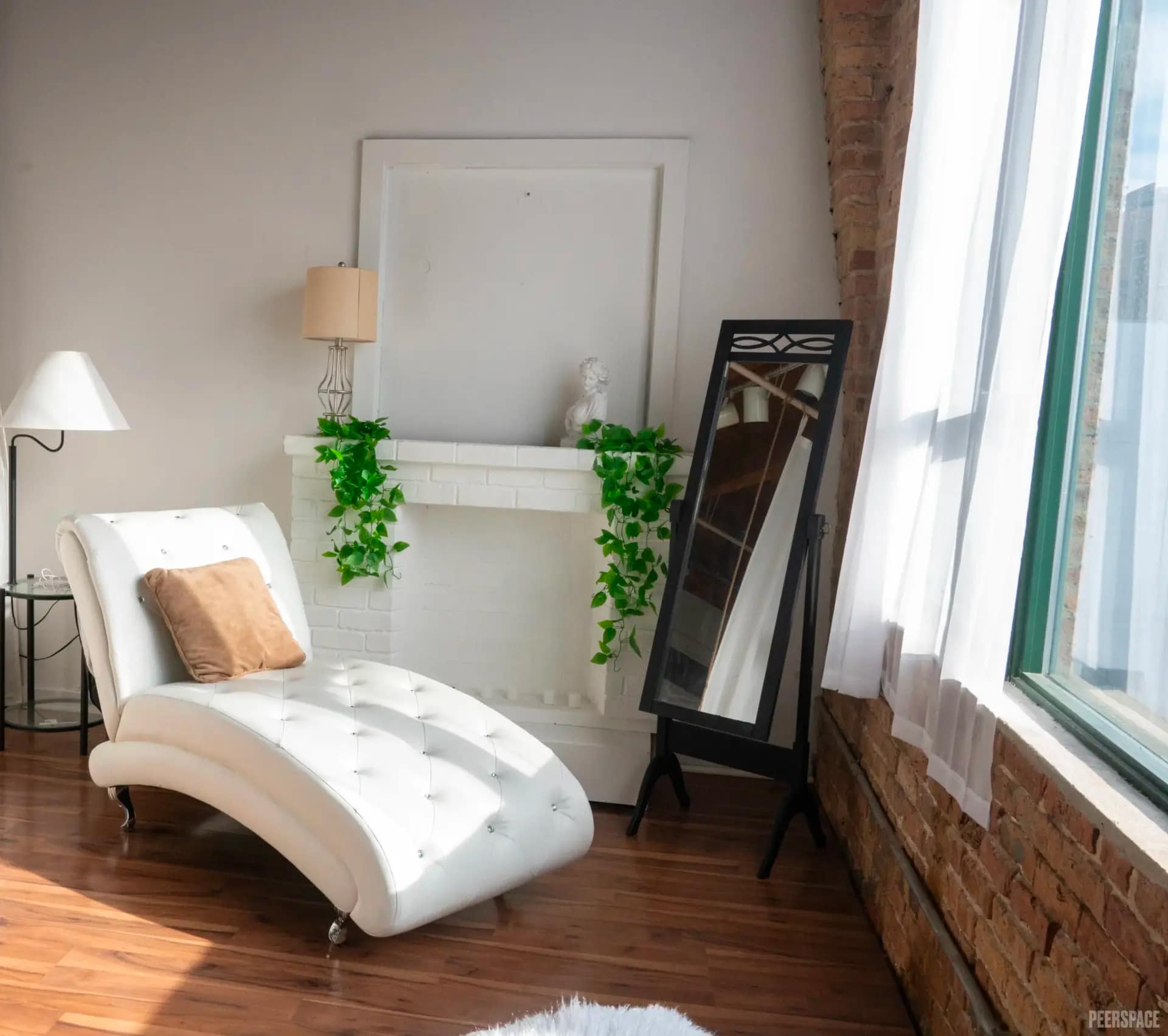 White chaise lounge, vintage mantel and brick wall corner at Chicago photography studio rental